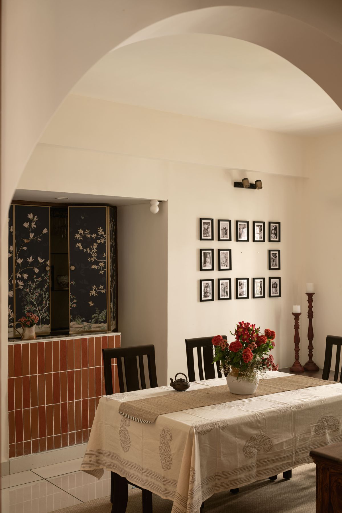 Dining room with arch, gallery wall and linen-dressed table