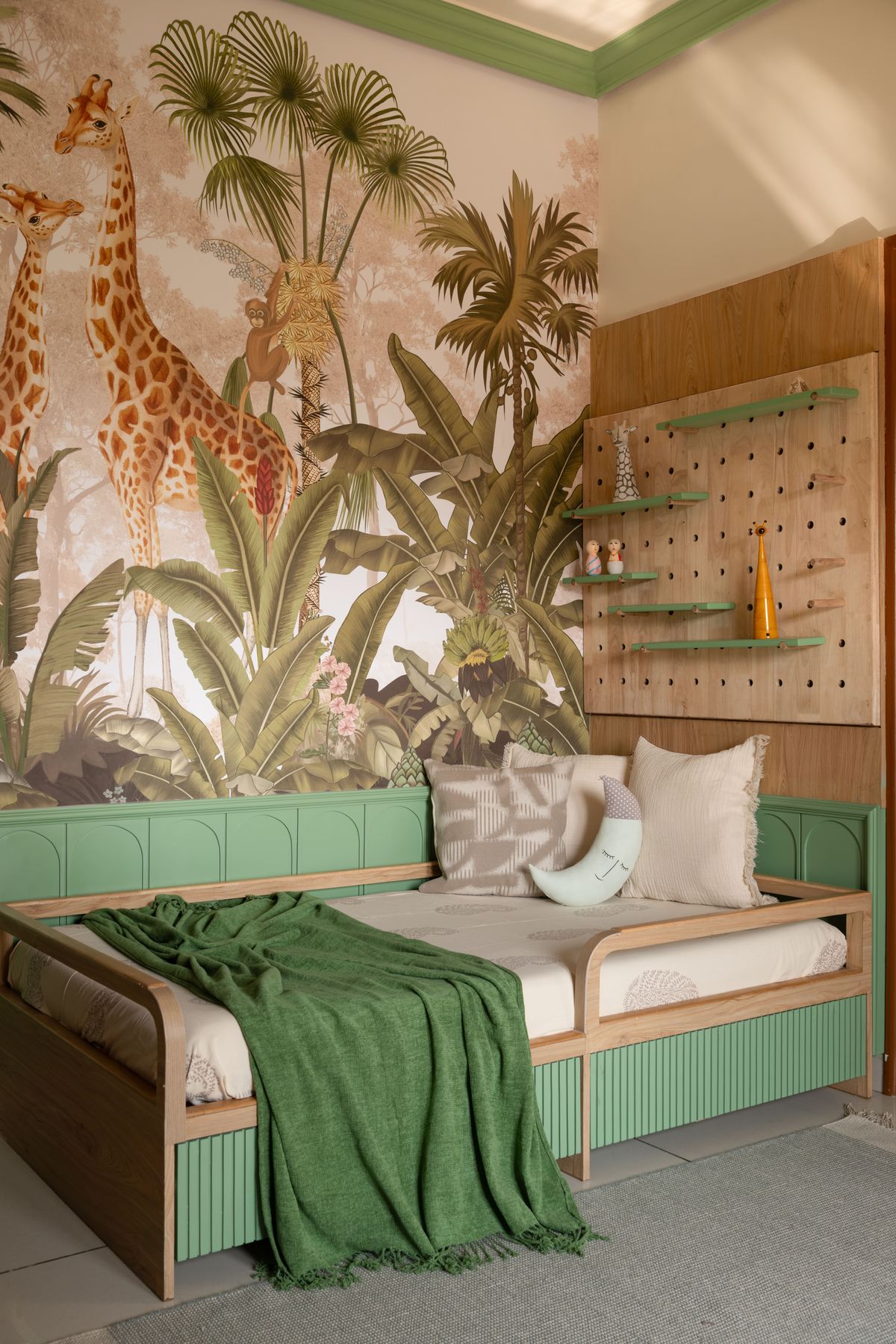 Kids' daybed with moon cushion under the jungle mural
