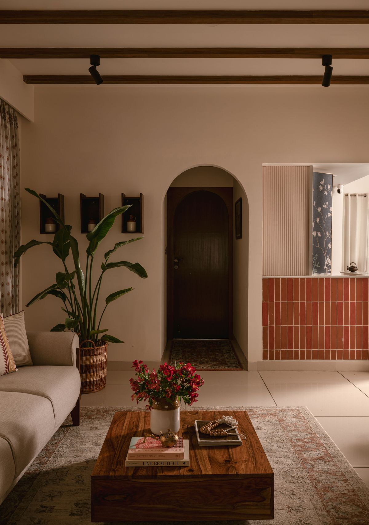 Living room with arched doorway, exposed beams and linen sofa