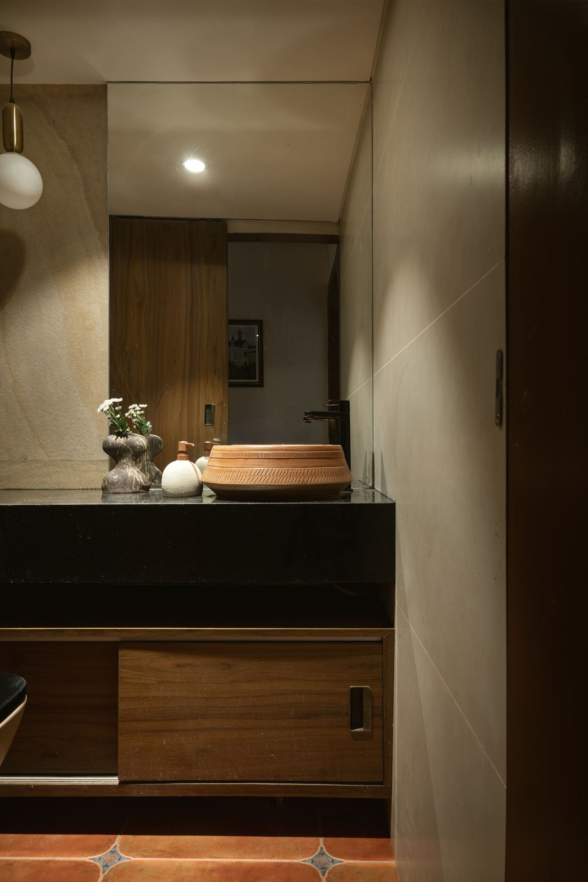 Powder room with hand-carved wooden basin on black stone